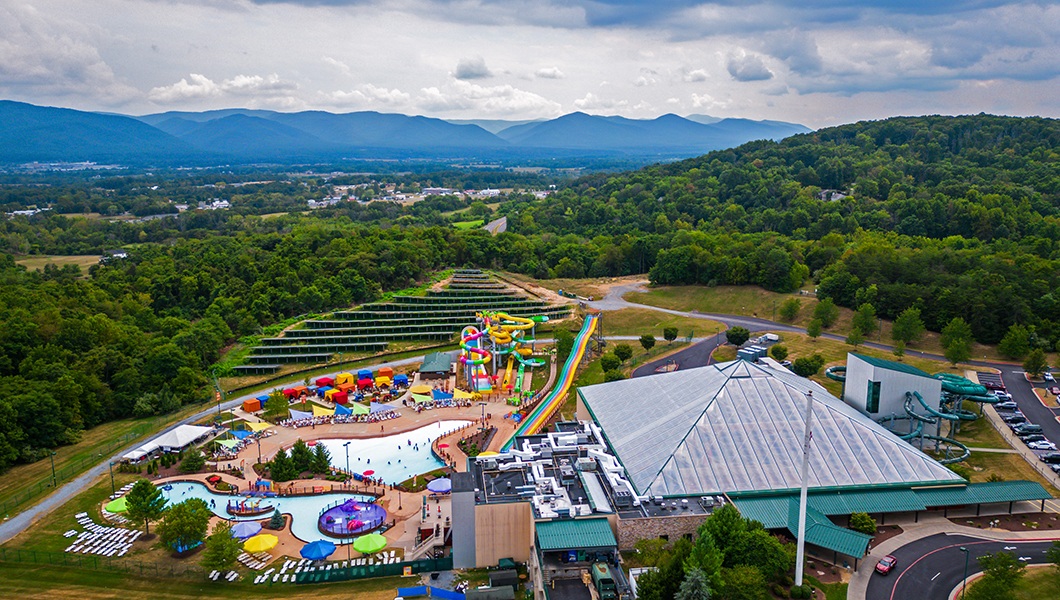 An aerial view of the Massanutten Indoor/Outdoor WaterPark with the mountains in the background