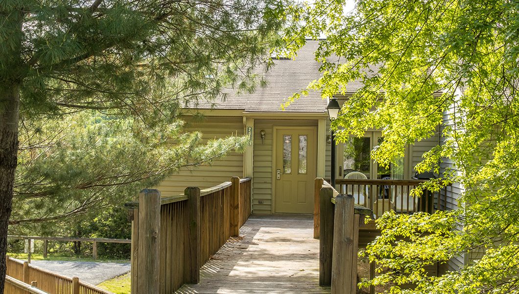 Entrance deck to Eagle Trace condo with green trees on both sides of deck