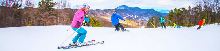 Two skiers and two snowboarders go down the Massanutten Ski Slopes